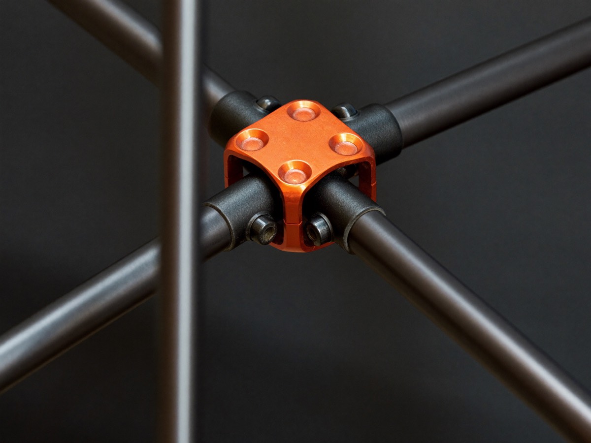 A central spine hub being locked, poles radiating from it.