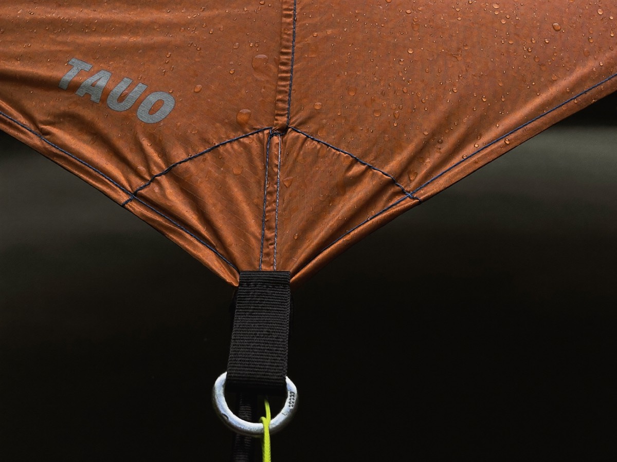 The fly being drawn over the canopy and tensioned at the corners.