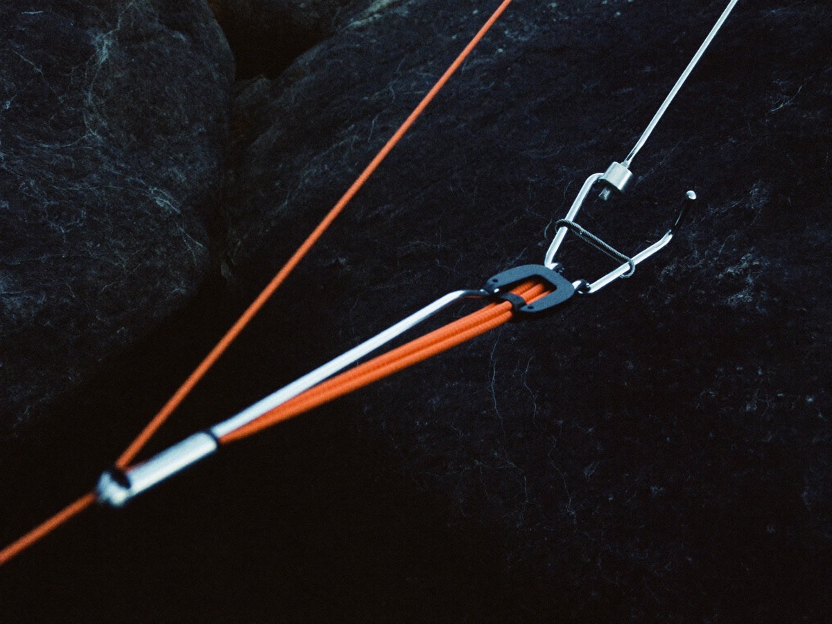 Guy lines being anchored and tensioned against a darkening sky.