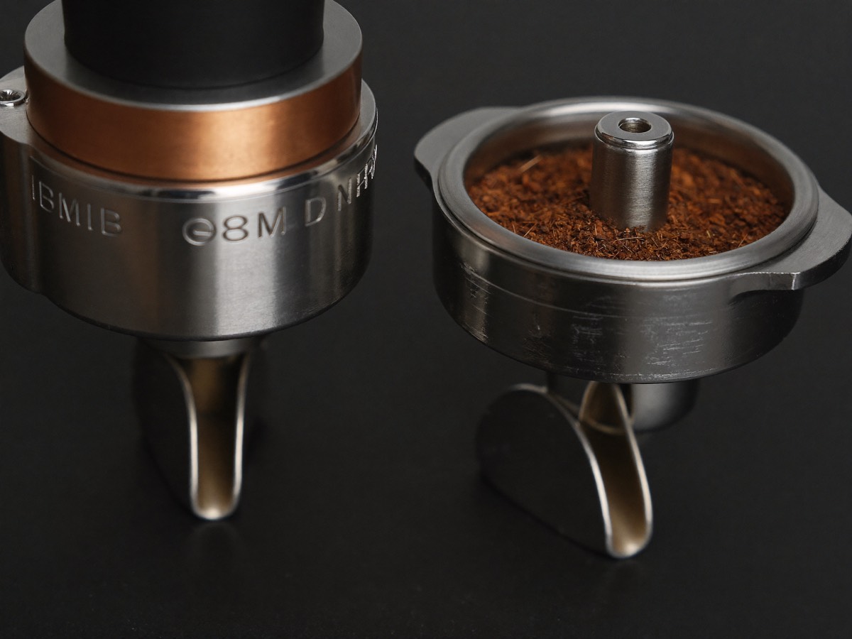 Ground coffee falling from stepless conical burrs.