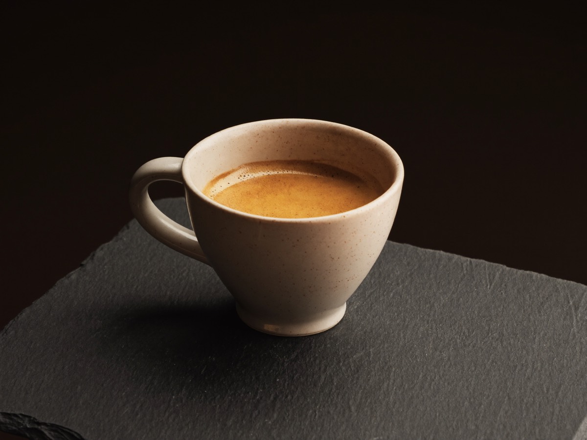 A finished espresso poured into a warm ceramic cup.